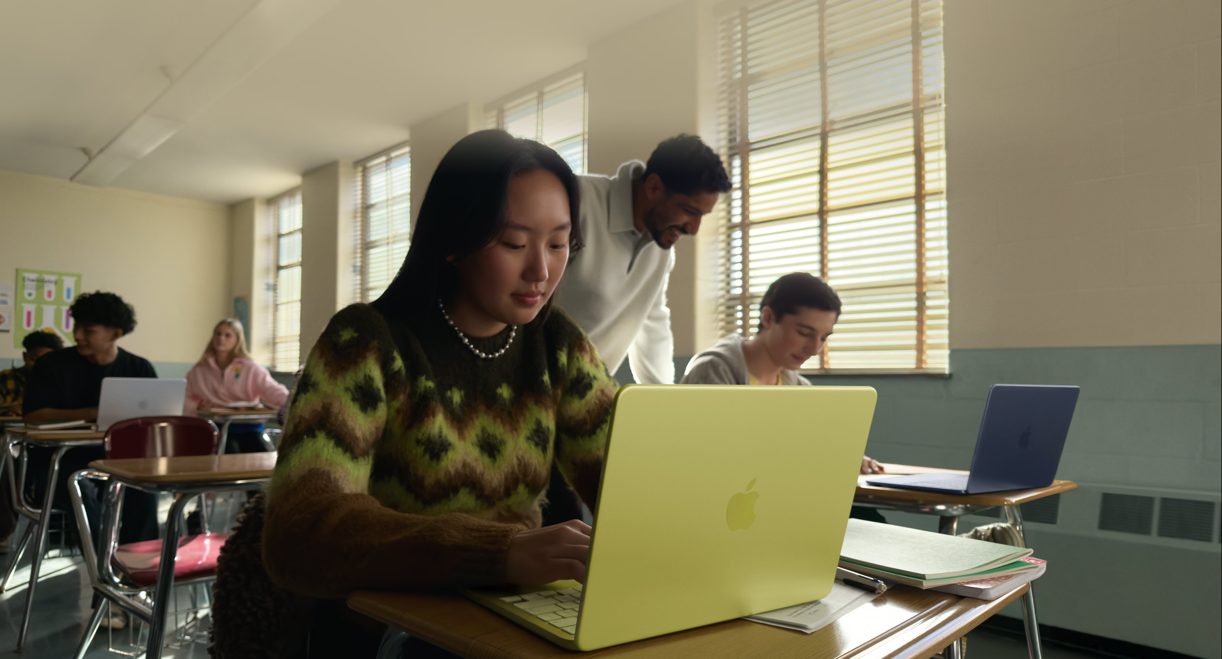 A student working on a laptop in a classroom.